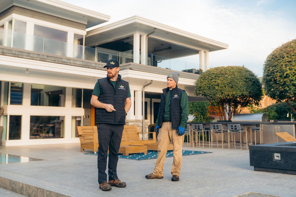 Two workers standing outside modern luxury home