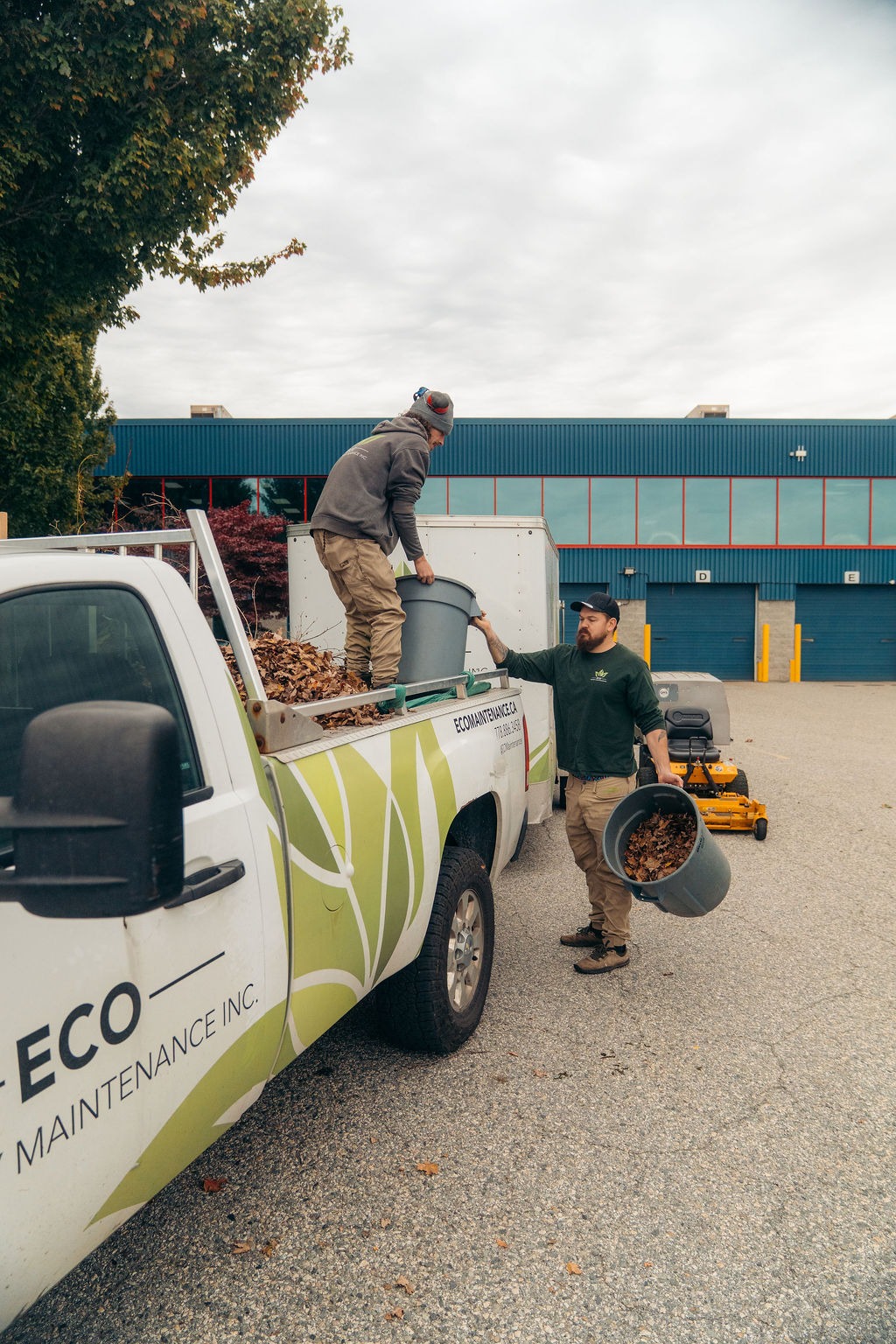 Landscapers loading leaves into pickup truck
