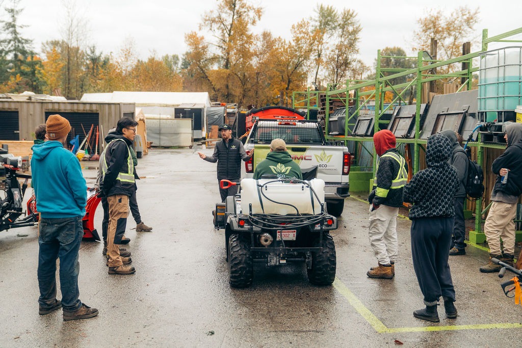 Workers gathered around utility vehicle in industrial yard