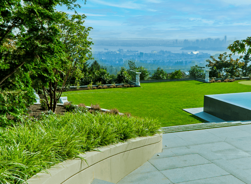 Landscaped backyard overlooking distant city skyline and water