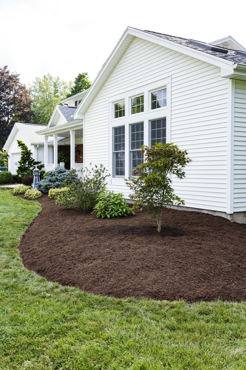White house with fresh mulch landscaping bed