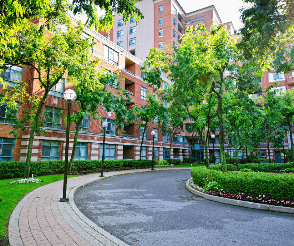Strata complex with neatly manicured lawn, hedges, and a paver stone walkway