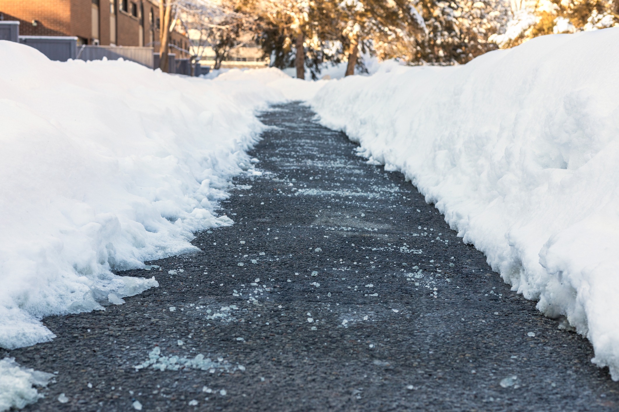 Cleared sidewalk between snowbanks in winter