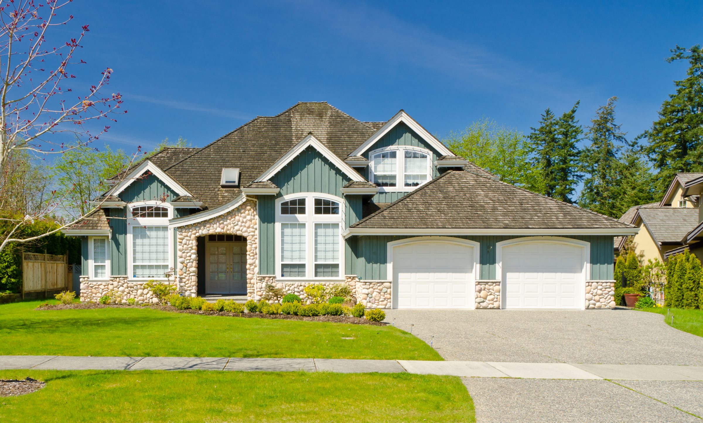 Large suburban house with stone facade and double garage
