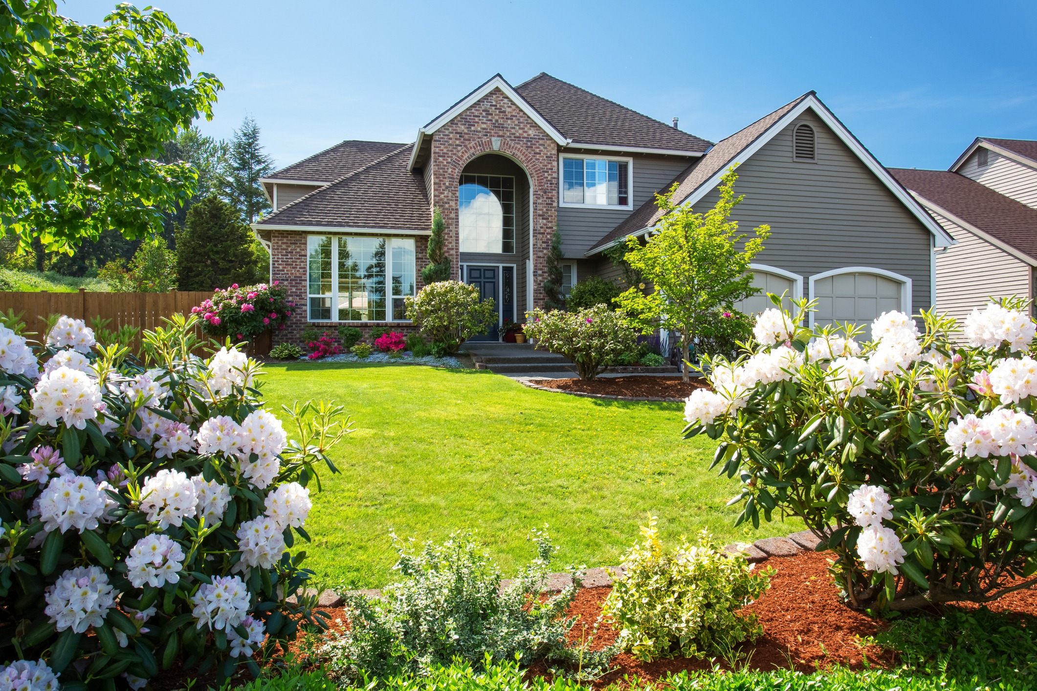 Suburban brick house with landscaped garden and lawn