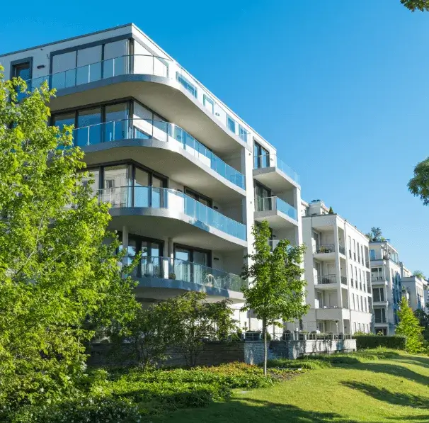 Modern apartment building with glass balconies and greenery