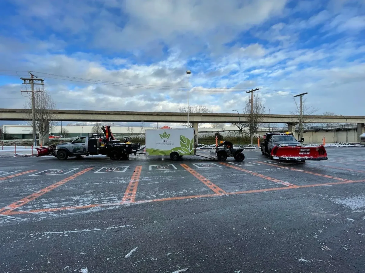 Snow removal trucks in icy parking lot