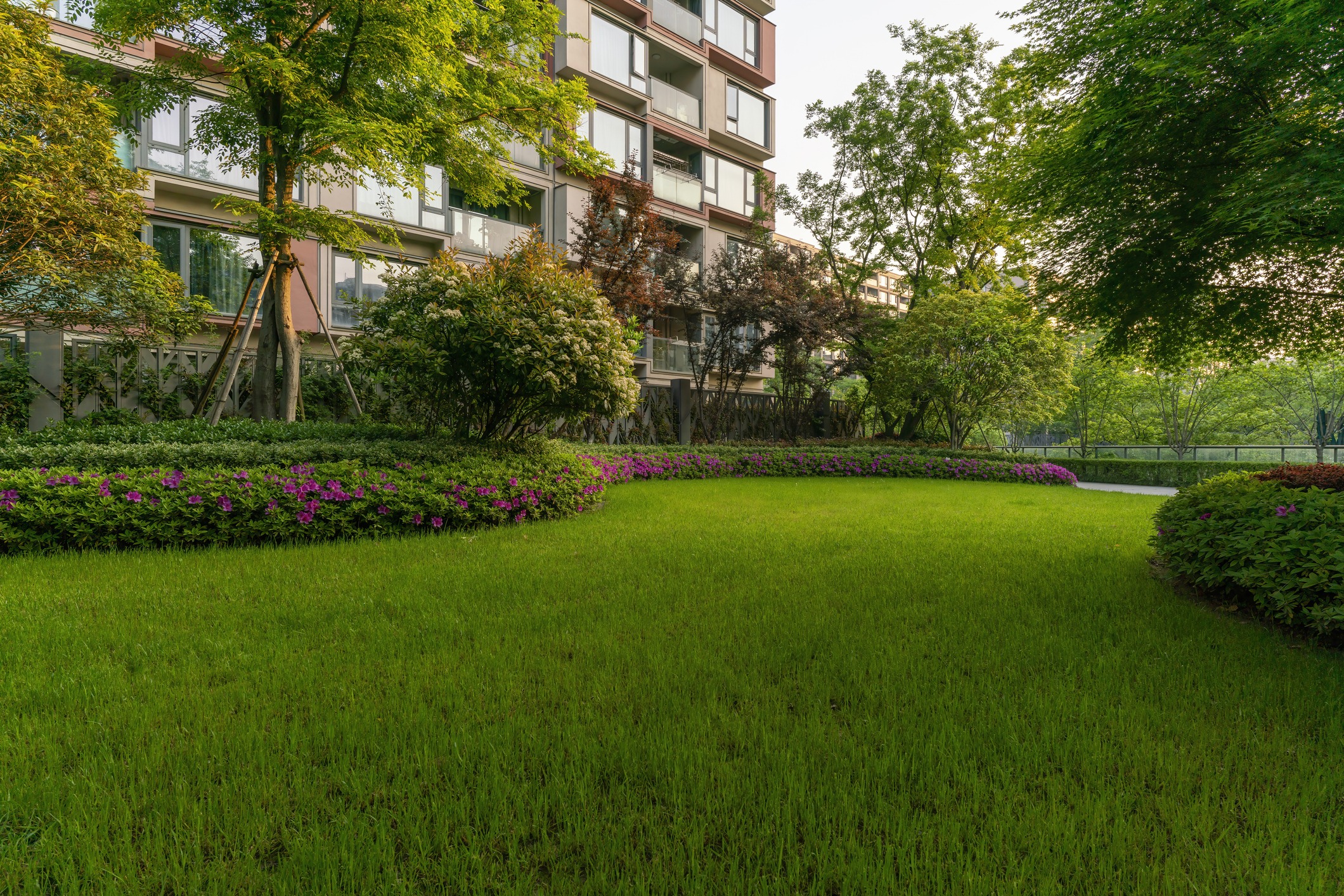 Modern apartment building with professionally landscaped and maintained green courtyard